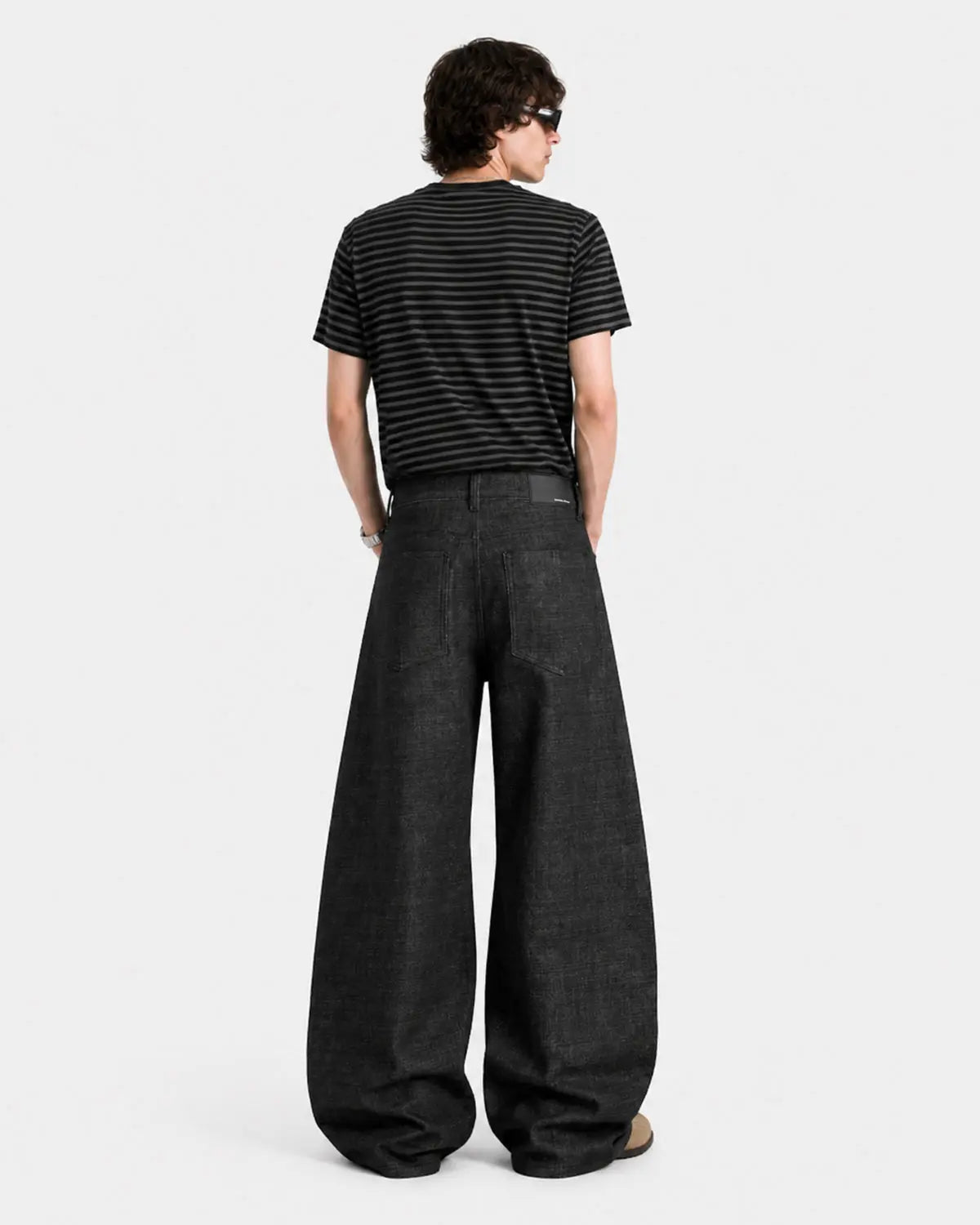 Deconstructed raw baggy jeans with button details from INFLATION's Streetwear collection, featuring a relaxed fit and distressed accents.