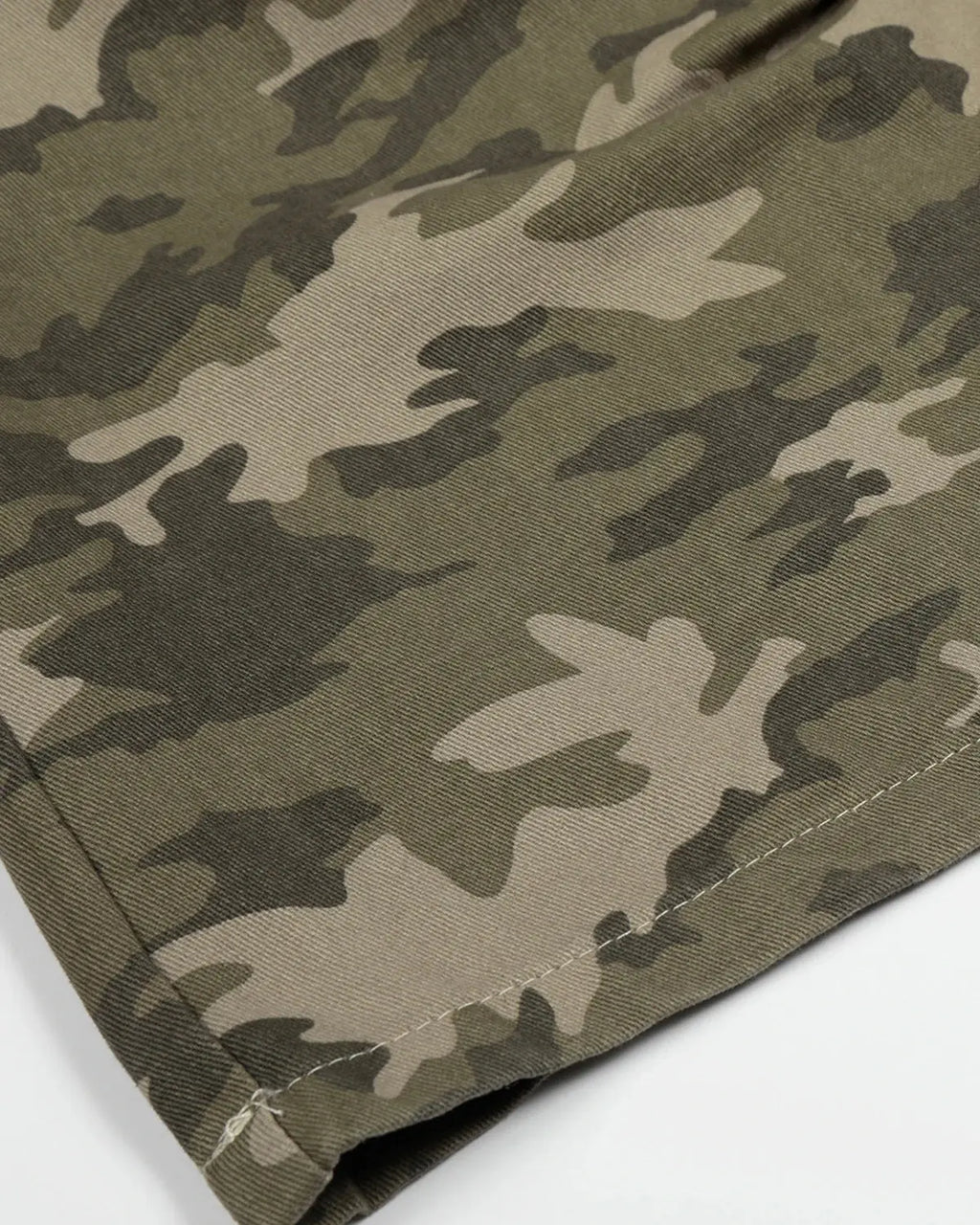 Embroidered camo cargo longline shorts by INFLATION featuring military-style camouflage pattern and casual fit.