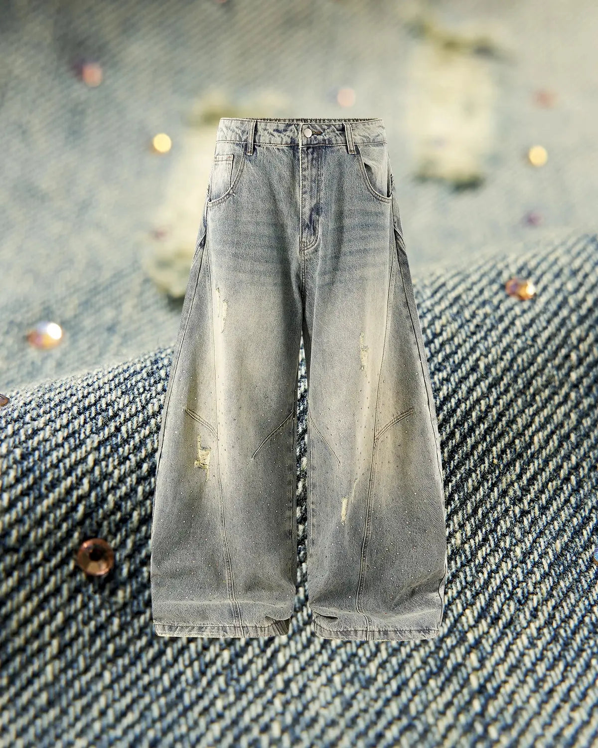 Colorful rhinestones embellish distressed baggy jeans from INFLATION, showcasing vibrant, ripped streetwear pants with a trendy, relaxed fit.