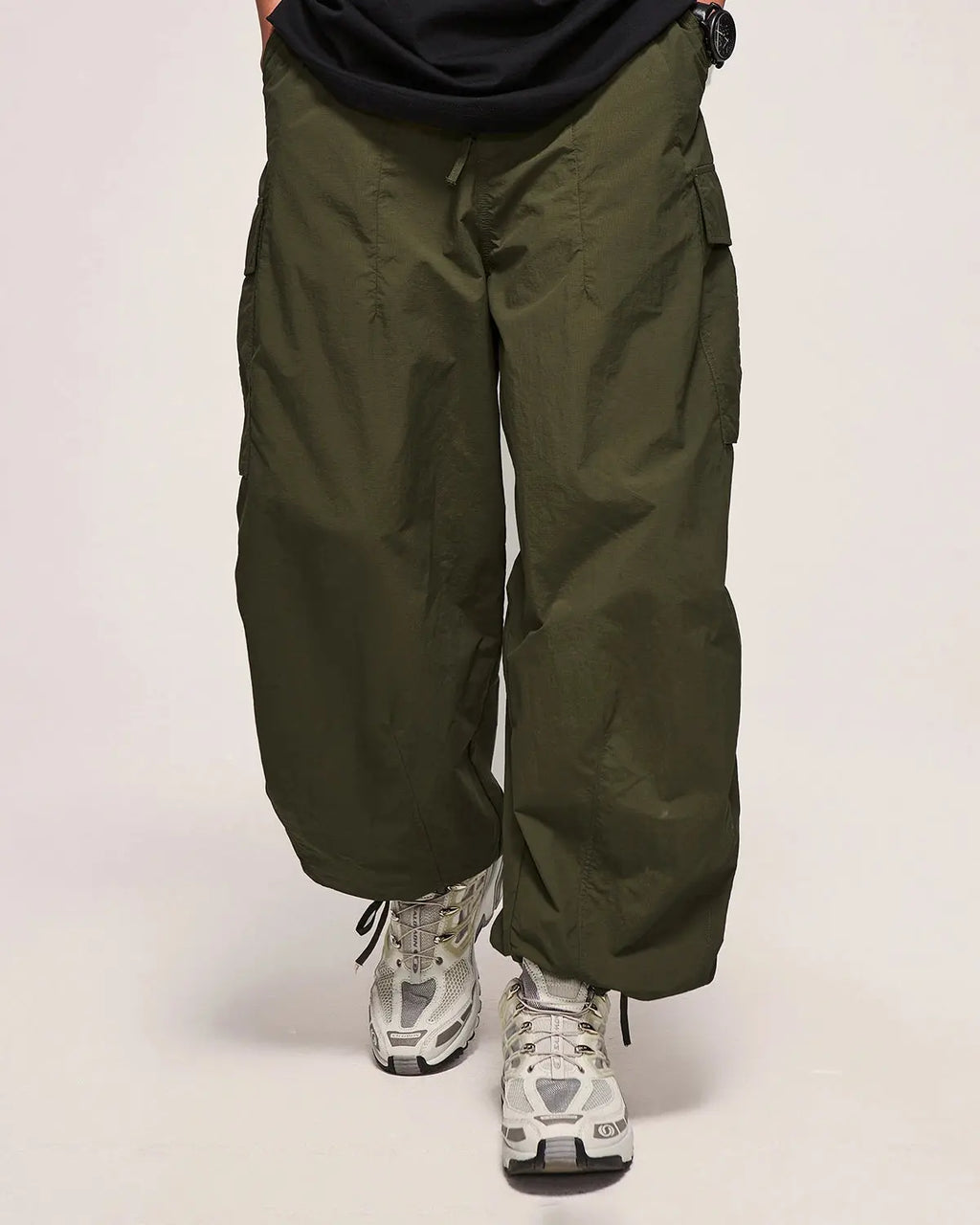 Black Flation Parachute Cargo Pants, streetwear style with multiple pockets and relaxed fit, showcased on a model.