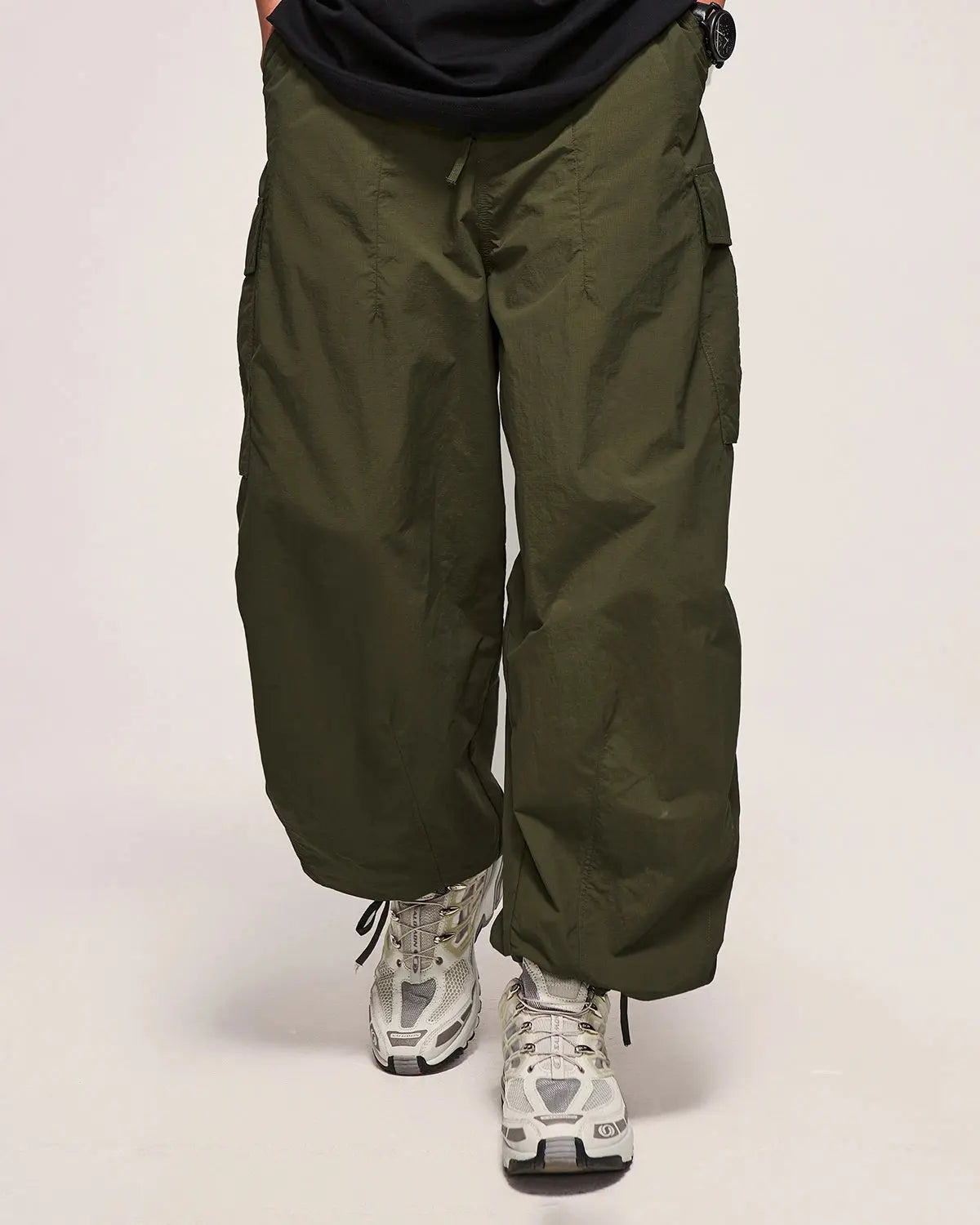 Black Flation Parachute Cargo Pants, streetwear style with multiple pockets and relaxed fit, showcased on a model.