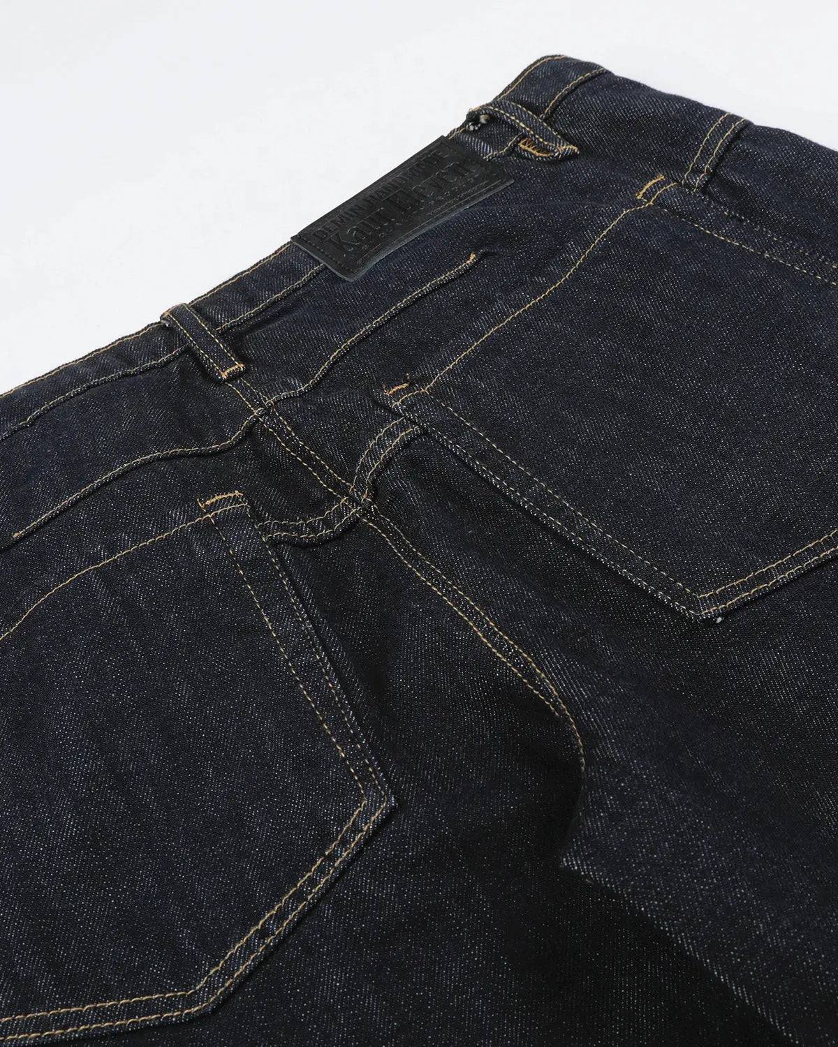 Black and blue wide-leg jeans with button details from Flation Streetwear, featuring a raw hem and relaxed fit.