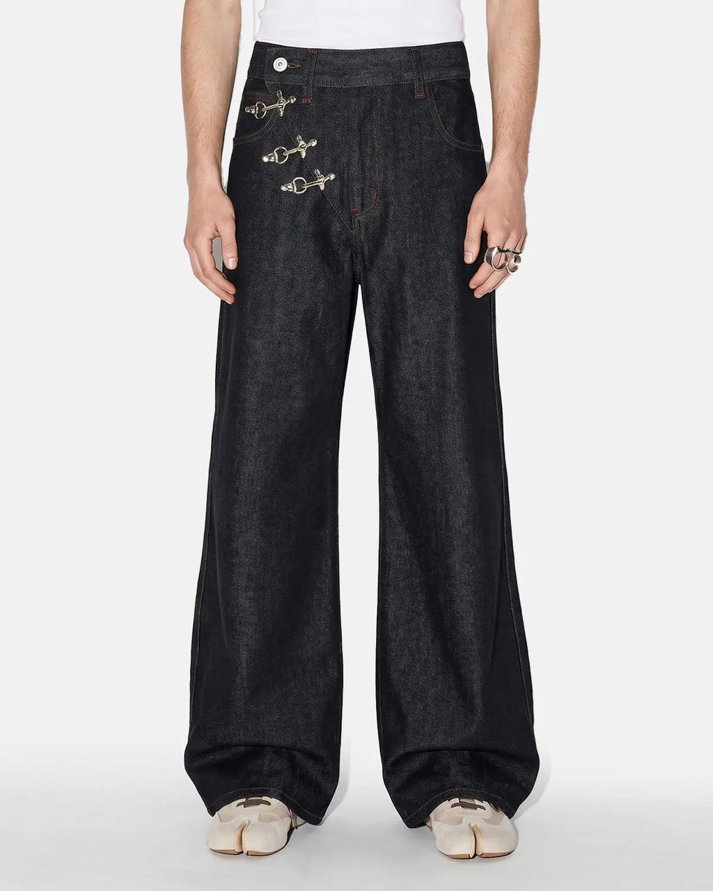 Black asymmetric buckle raw baggy jeans by Flation Streetwear, shown with a relaxed fit and distressed details.