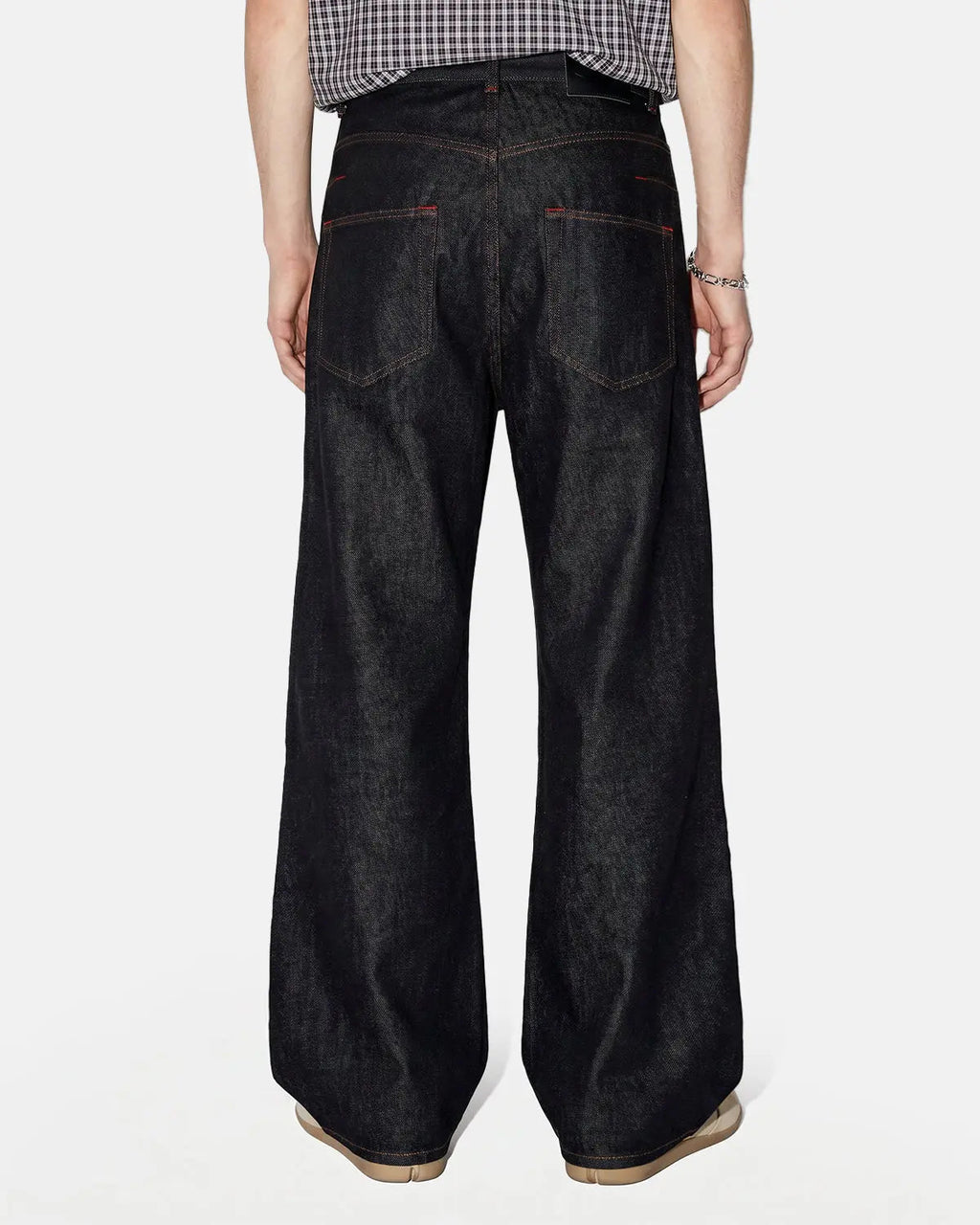 Black Flation asymmetric buckle raw baggy jeans with distressed detailing, streetwear style, relaxed fit, and unique asymmetric design.