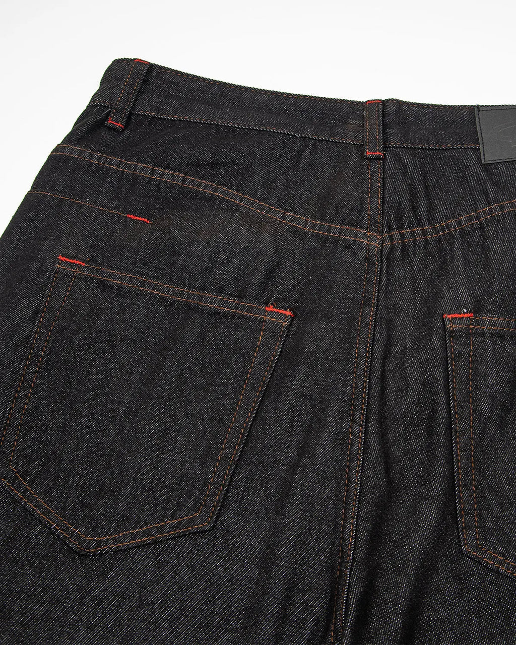 Black asymmetric buckle raw baggy jeans by Flation Streetwear, featuring a relaxed fit and unique design details.