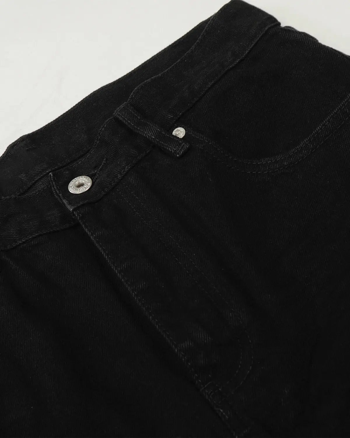 Black baggy jeans from Flation Streetwear with a relaxed fit and casual style, shown hanging on a clothing rack.