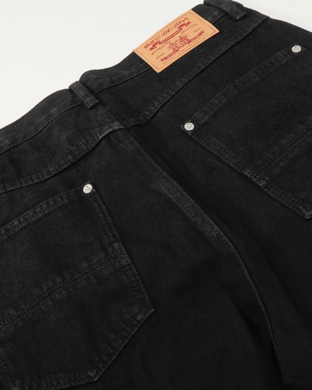 Black baggy jeans from Flation Streetwear with a relaxed fit and distressed detailing, styled with casual urban fashion.
