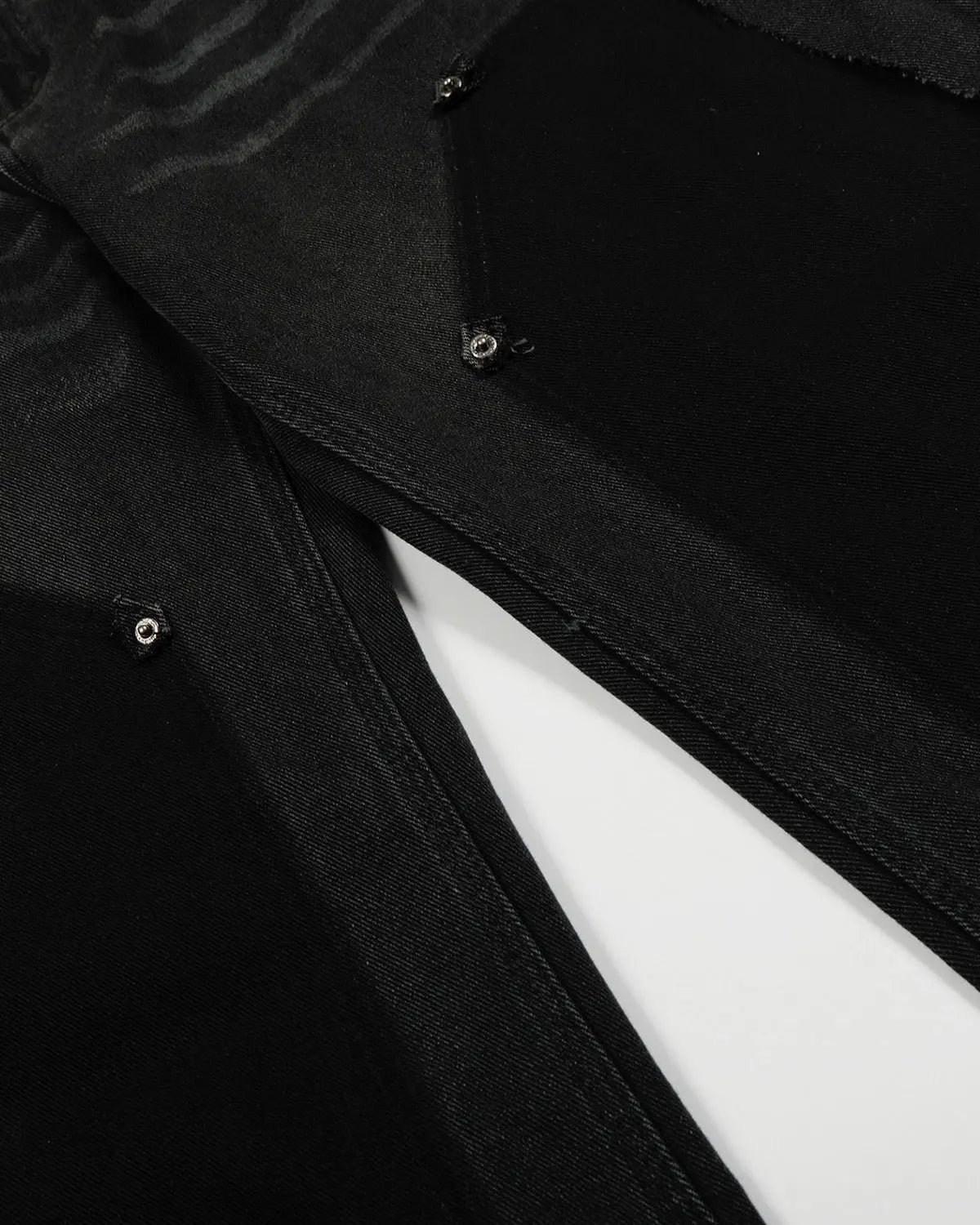 Black patchwork barrel jeans by INFLATION featuring a relaxed fit and unique patchwork design, displayed on a model.