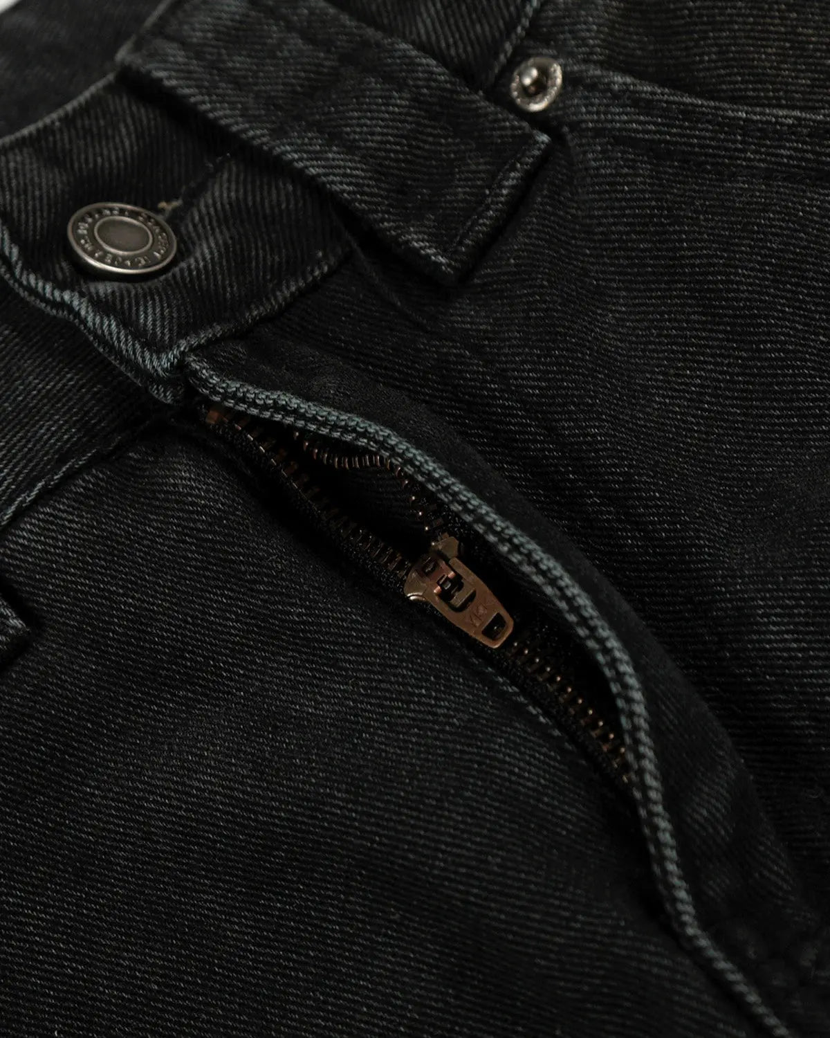 Black patchwork barrel jeans by INFLATION with distressed details and unique stitching, styled on a mannequin.