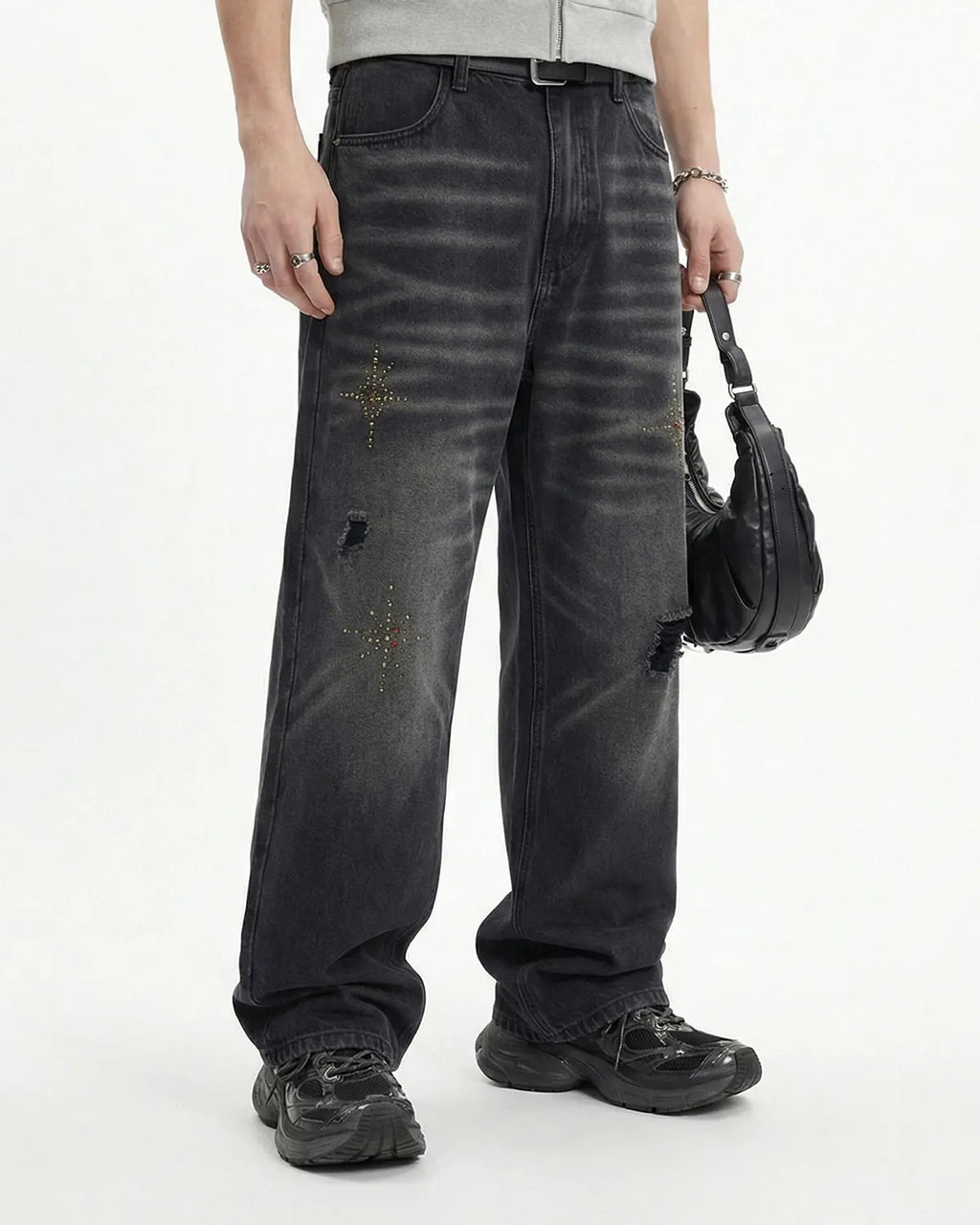 Distressed rhinestone ripped baggy jeans by Flation featuring a loose fit, torn details, and sparkling rhinestone accents.