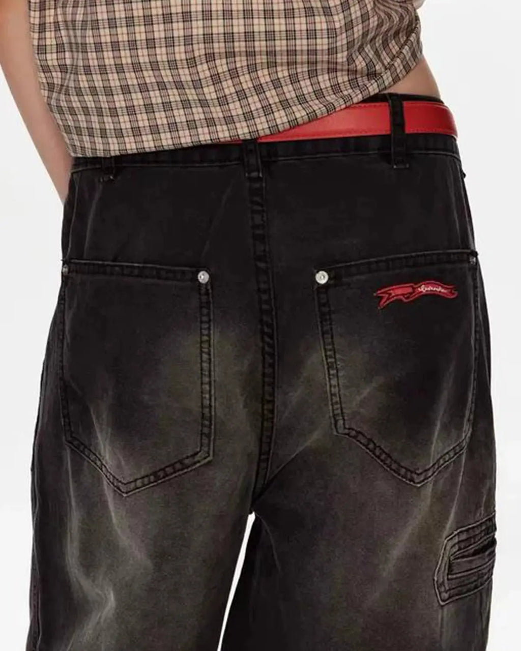 Retro washed wide-leg jeans by Flation Streetwear hanging on a wooden background, showcasing their relaxed fit and vintage style.