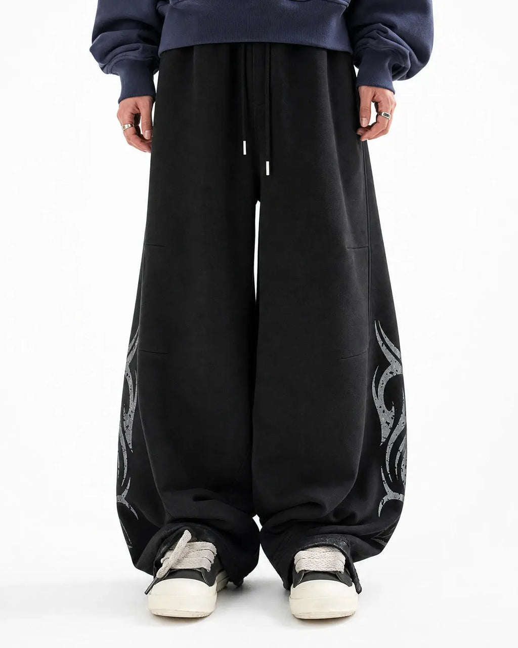 Black washed distressed barrel sweatpants by Flation Streetwear, featuring a relaxed fit and trendy distressed details.