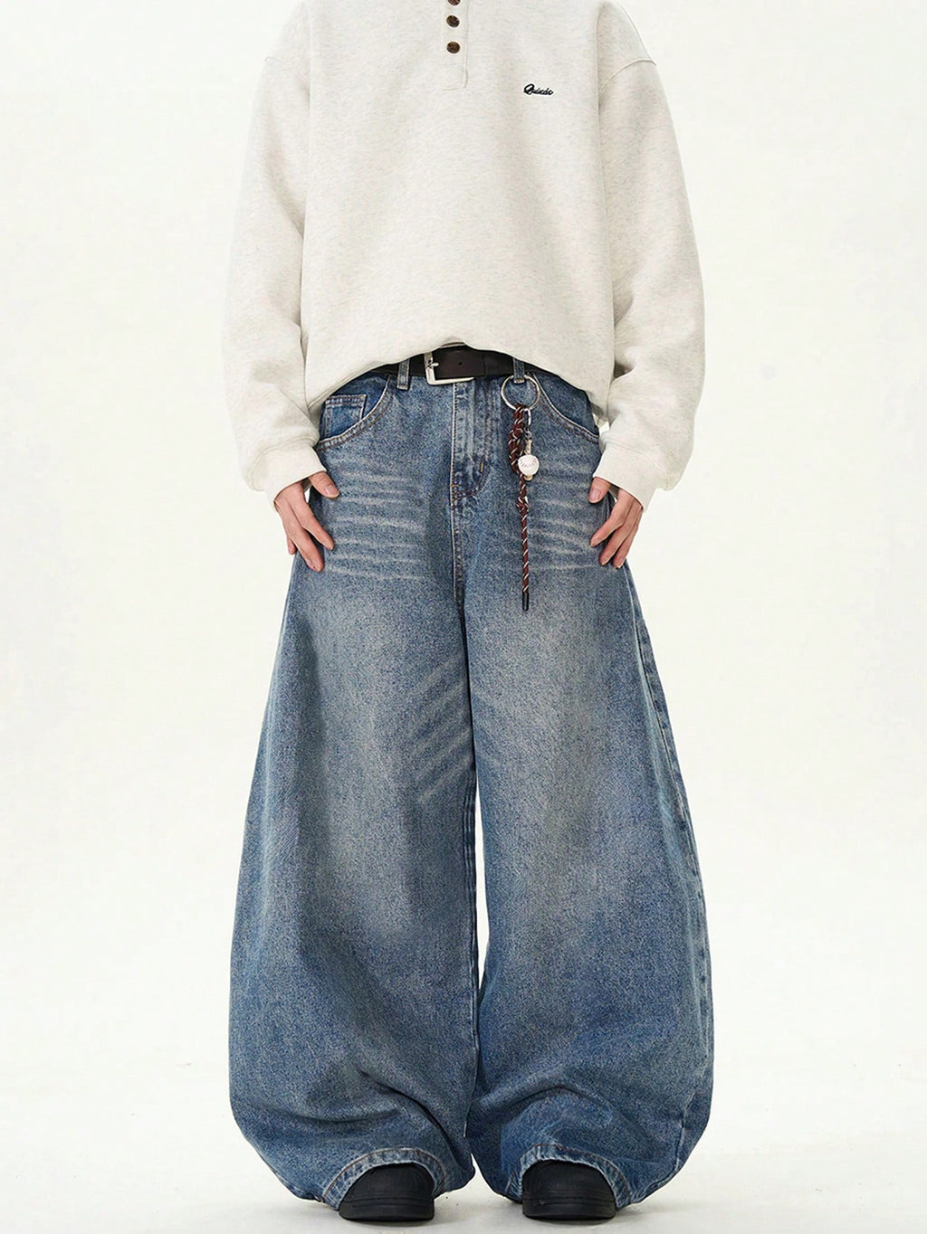 Black Flation wide-leg loose fit distressed vintage denim jeans laid flat, showcasing their relaxed fit and distressed detailing.