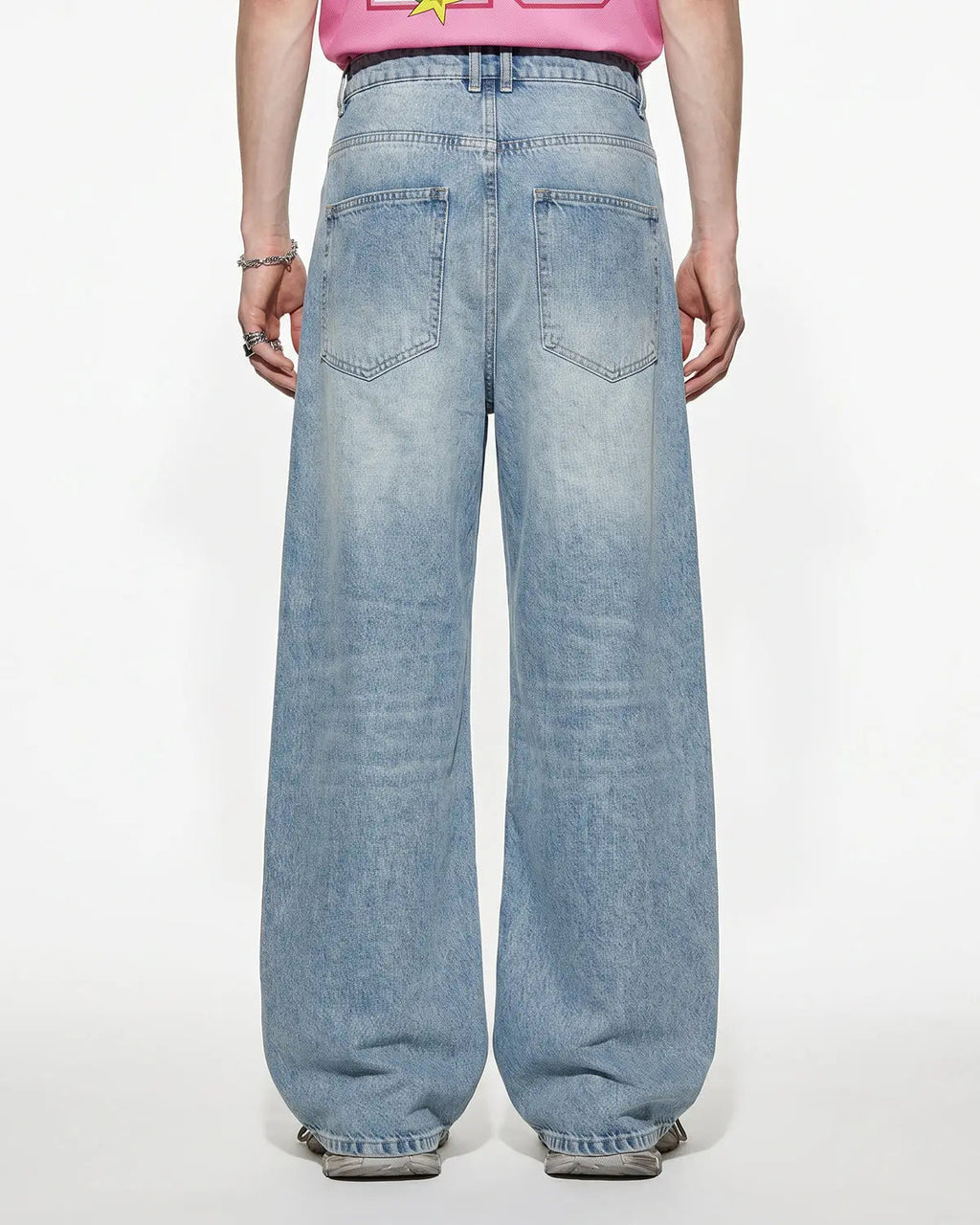 Blue asymmetric button baggy jeans by Flation, featuring loose fit and streetwear style, shown on a model.