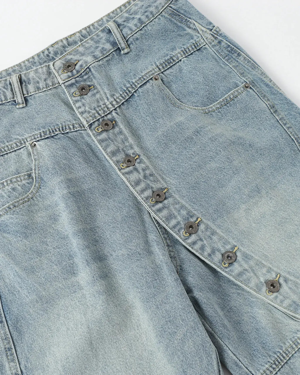 Blue asymmetric button baggy jeans by Flation Streetwear, featuring relaxed fit and stylish design with prominent front buttons.