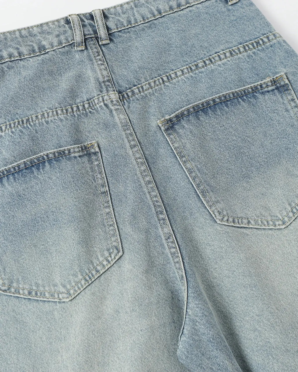 Blue asymmetrical button baggy jeans by Flation Streetwear, featuring loose fit, stylish design, and casual streetwear style.