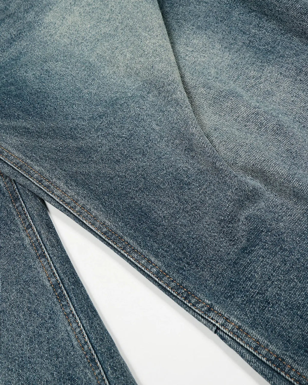 Blue acid-washed barrel jeans by Flation with whisker detailing, styled as streetwear casual, shown on a model.