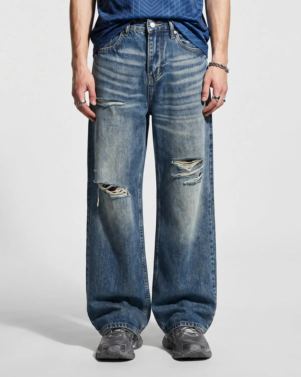 Blue distressed baggy jeans from Flation's Whisker Wash collection, featuring a relaxed fit and streetwear style.