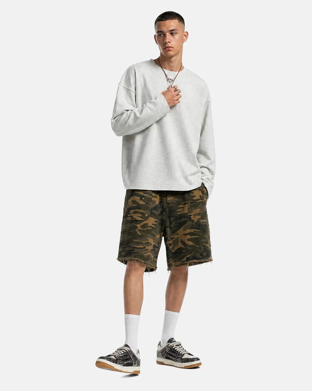 Flation camo knee-length shorts with frayed hem, casual streetwear style, featuring a green and brown camouflage pattern.