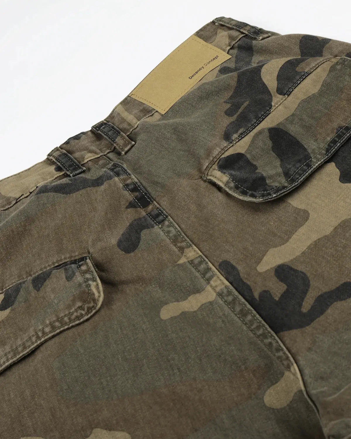 Camo cargo barrel pants by Flation featuring adjustable waist and multiple pockets, styled with streetwear-inspired design.
