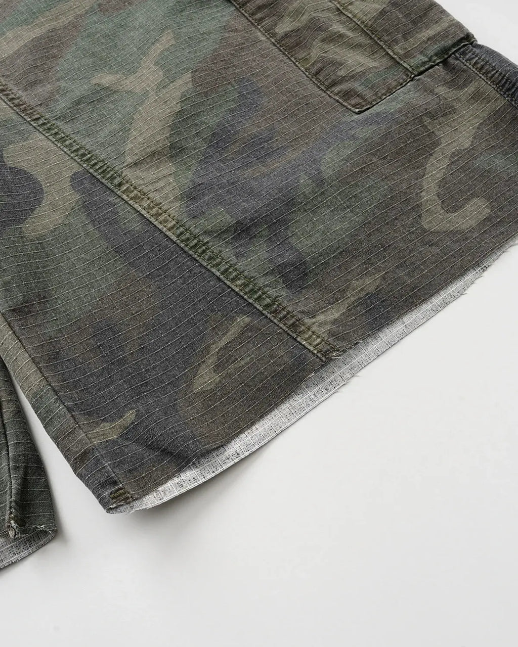 Camo utility longline shorts by Flation Streetwear featuring a camo pattern, multiple pockets, and a relaxed fit.