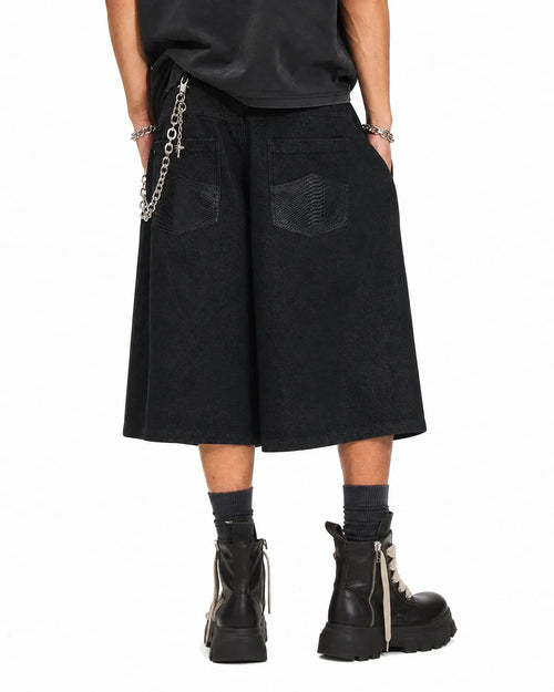 Black baggy long jorts by Flation Streetwear featuring a relaxed fit, distressed denim, and casual street style design.