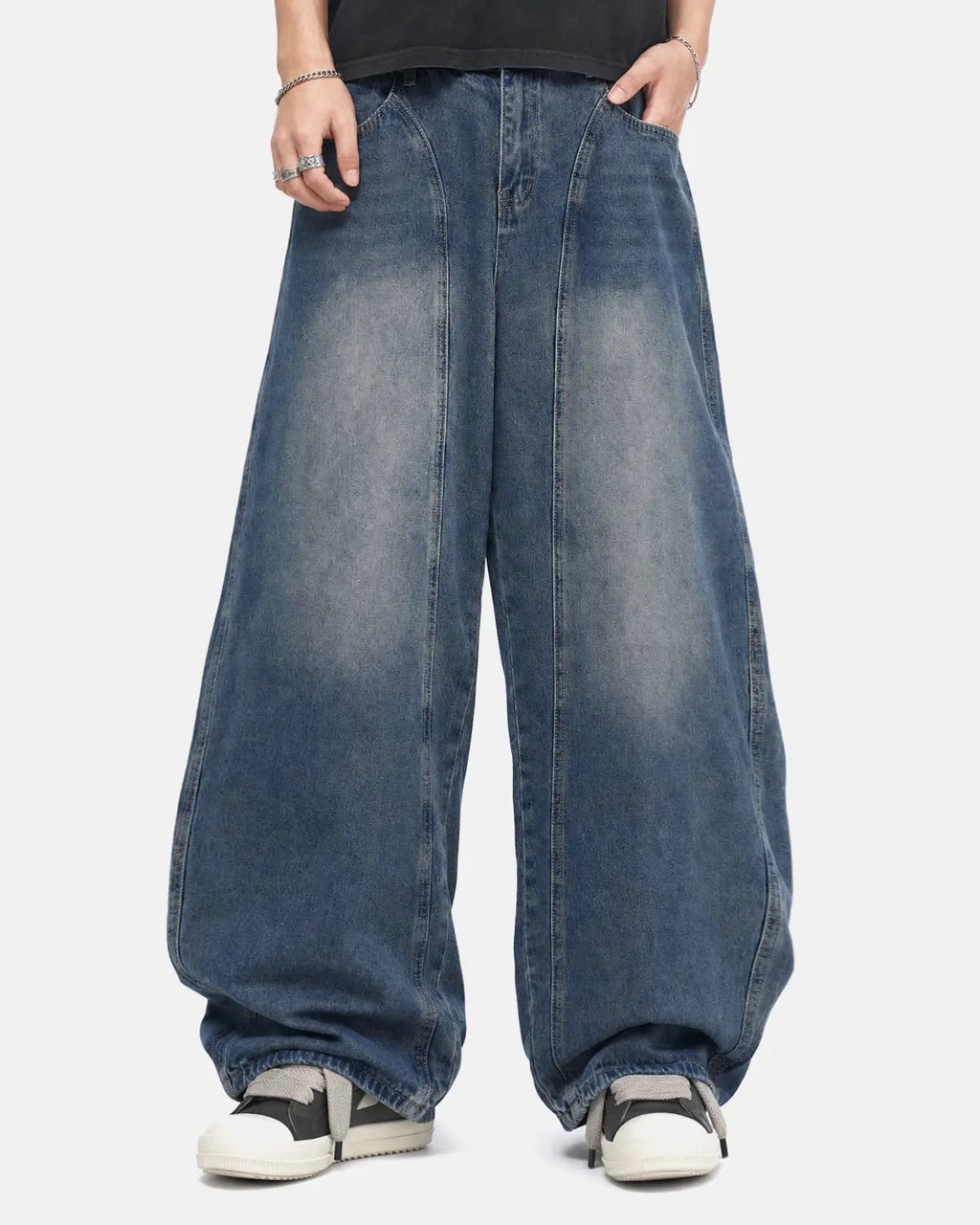 Deconstructed barrel jeans by INFLATION featuring distressed details and unique streetwear style, shown on a model.