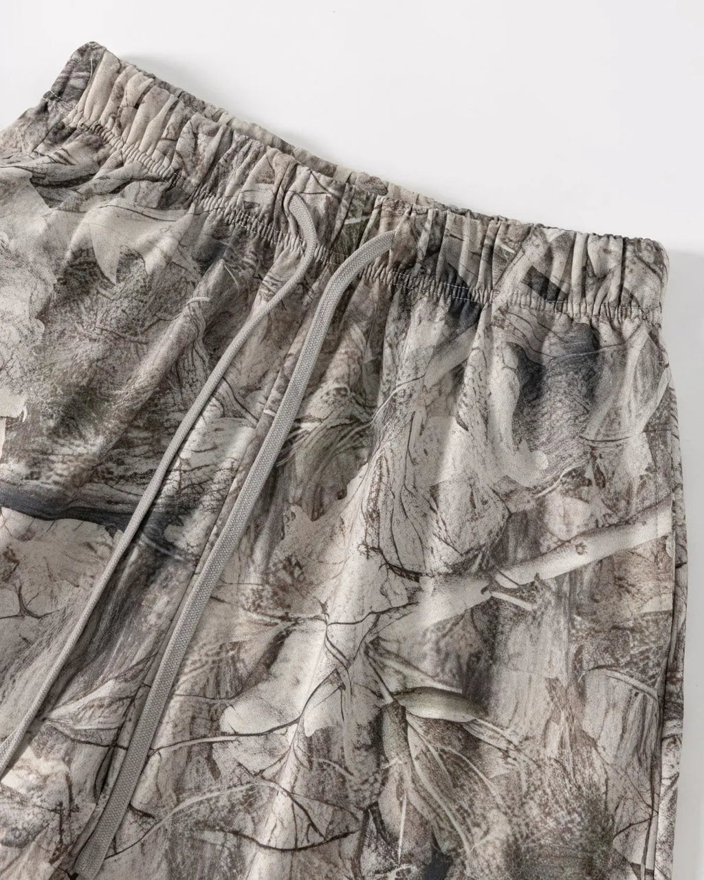 Realtree camo shorts by Flation, casual streetwear pants with a green and brown camouflage pattern, laid flat for display.