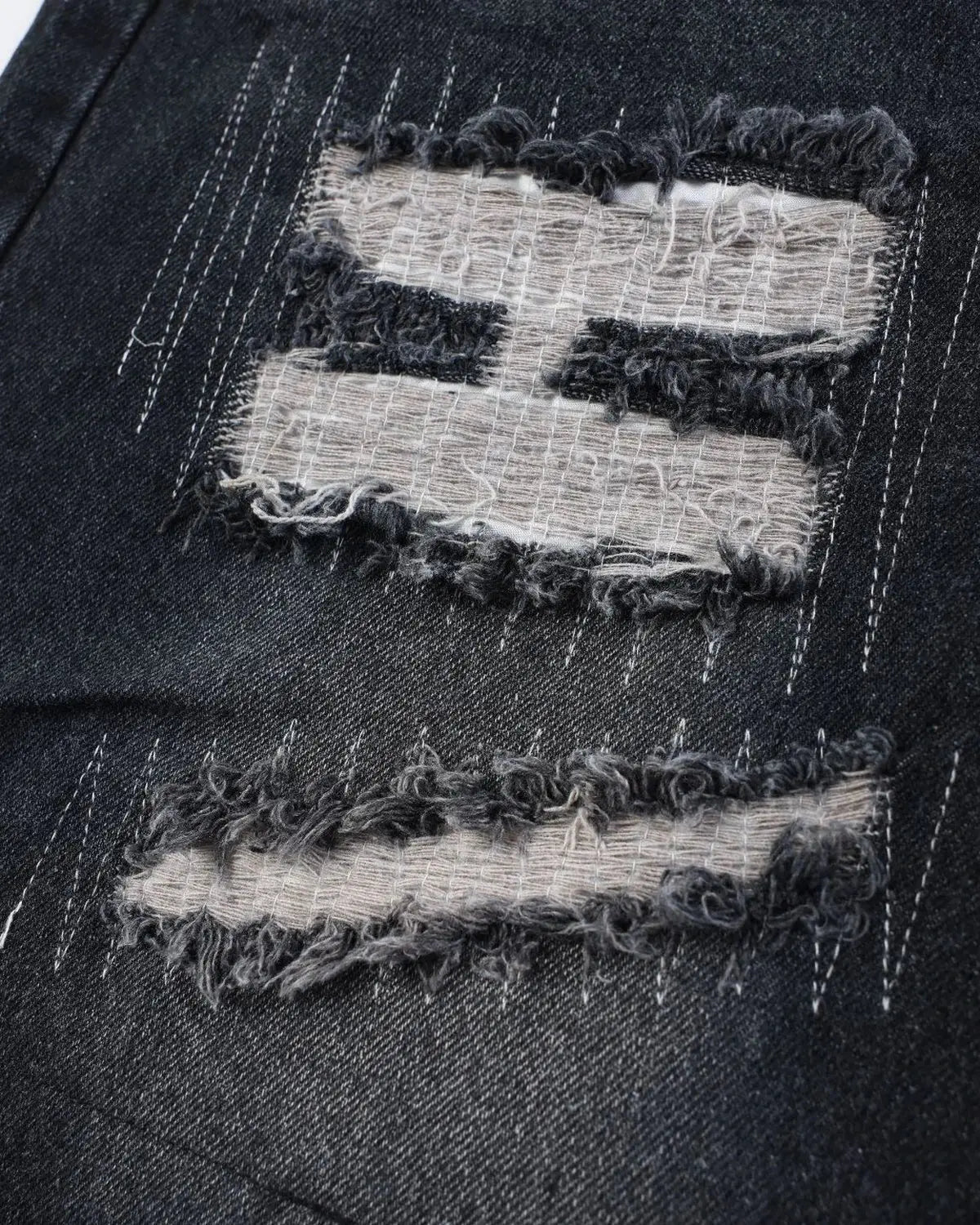 Black camo patchwork washed denim jorts by Flation Streetwear, showcasing distressed denim shorts with a rugged patchwork design.
