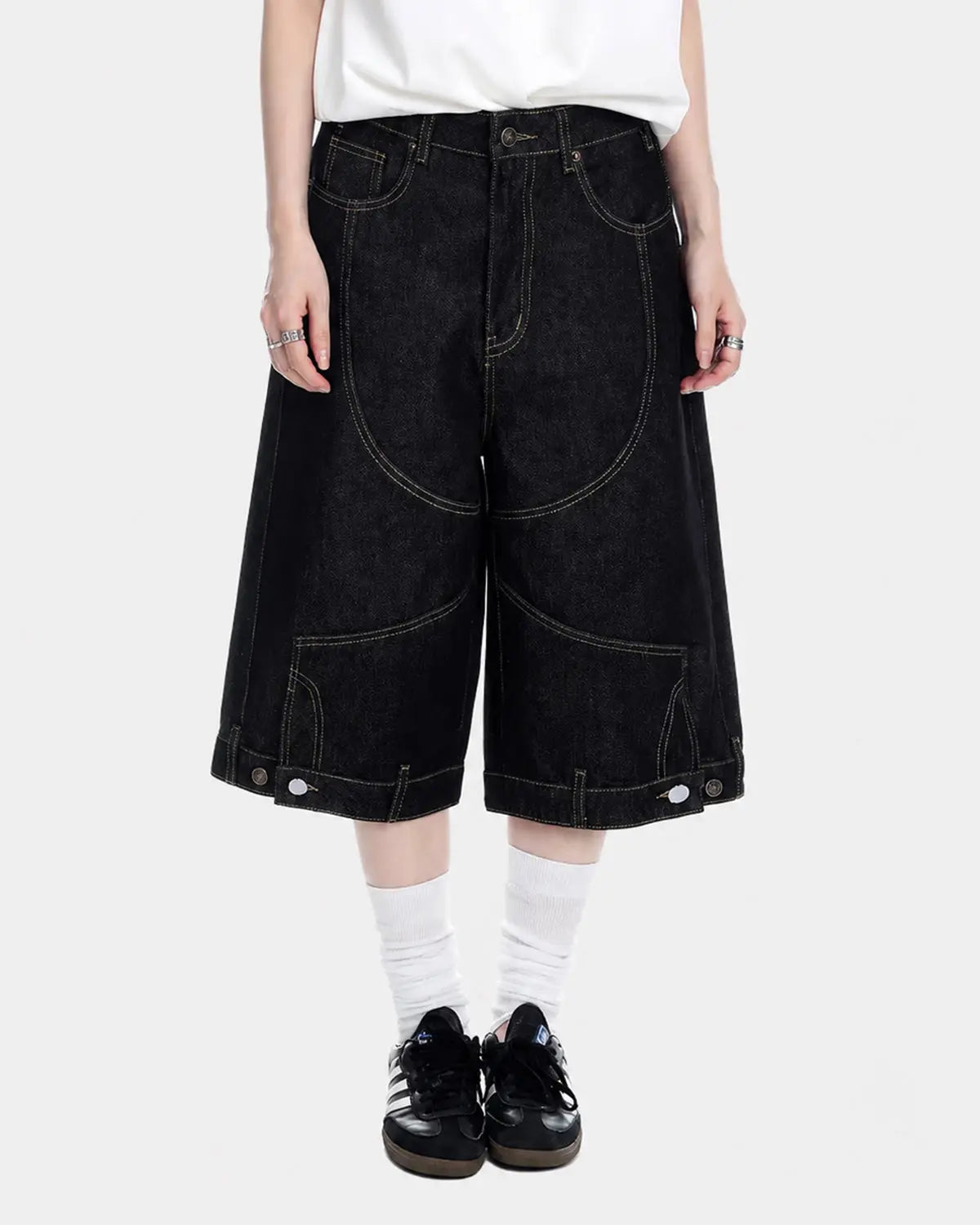 Black deconstructed raw denim jorts by Flation Streetwear, showing distressed details and casual fit on pants.