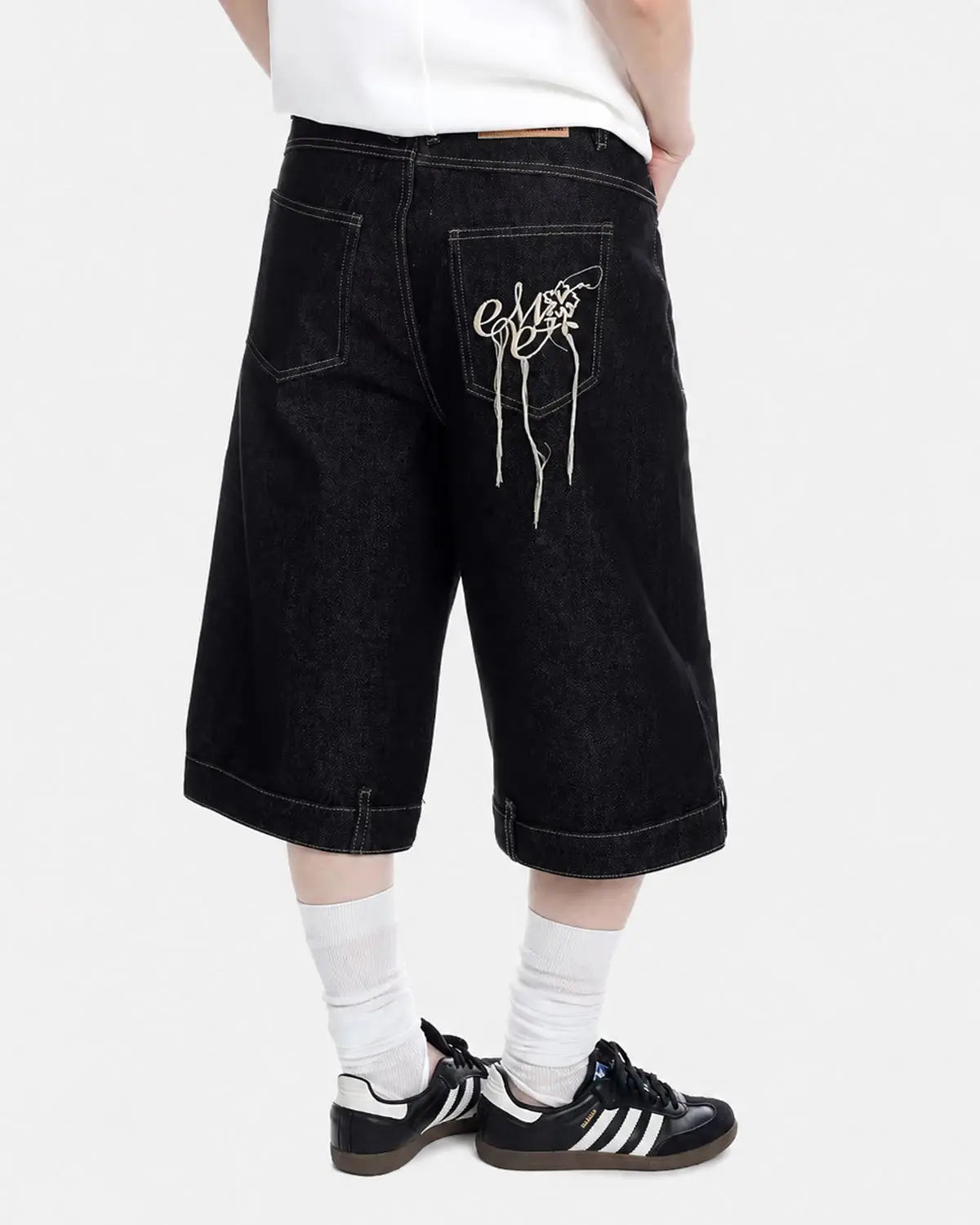 Black deconstructed raw denim jorts by Flation Streetwear, casual pants with distressed details and frayed hems.
