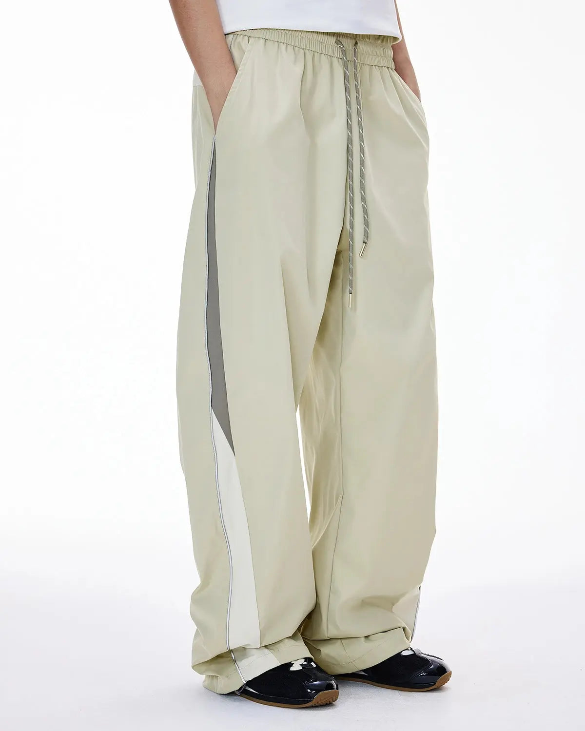 Reflective Flation streetwear windbreaker track pants with sporty design, lightweight fabric, and reflective detailing for active wear.