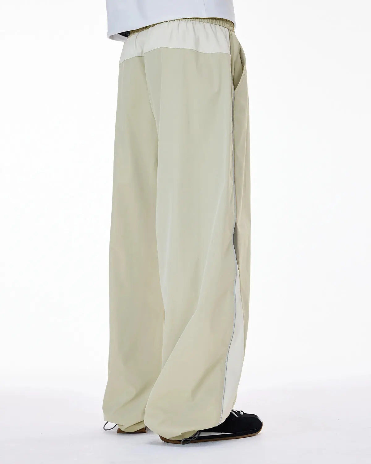 Reflective windbreaker track pants by Flation Streetwear featuring a sporty design with reflective accents and adjustable waistband.