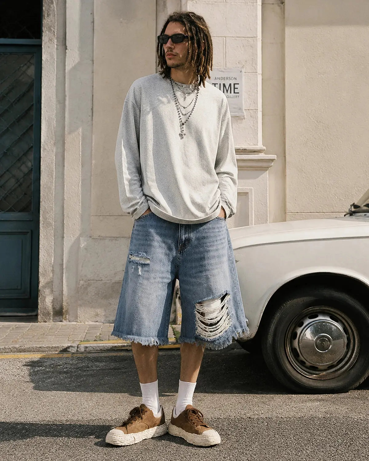Blue distressed baggy jorts with adjustable waist tabs, casual streetwear pants from Flation, featuring a relaxed fit and rugged style.