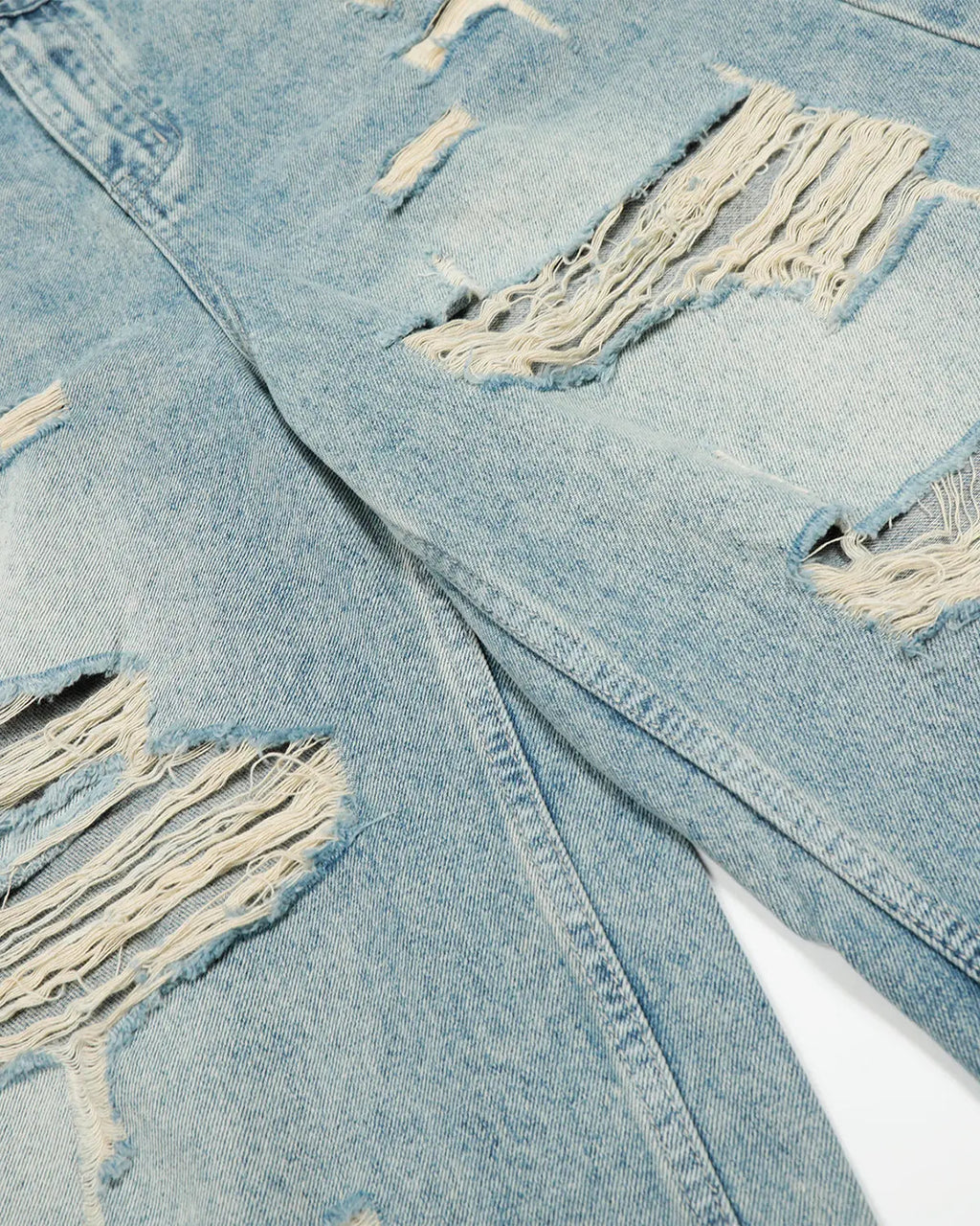 Blue distressed longline jorts pants by Flation Streetwear, featuring a relaxed fit and frayed hems.