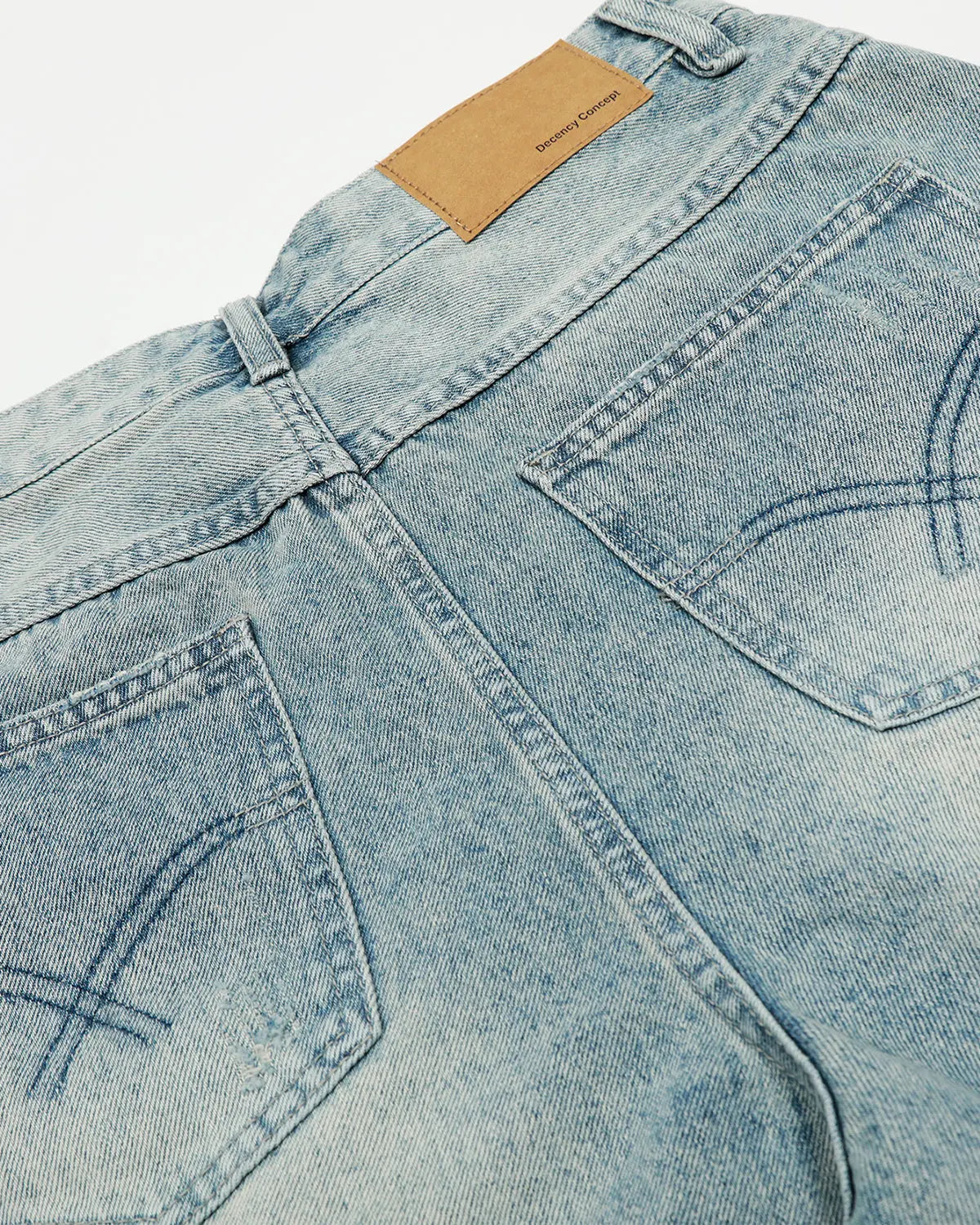Blue distressed longline jorts by Flation Streetwear, showing rips and frayed edges on casual denim pants.