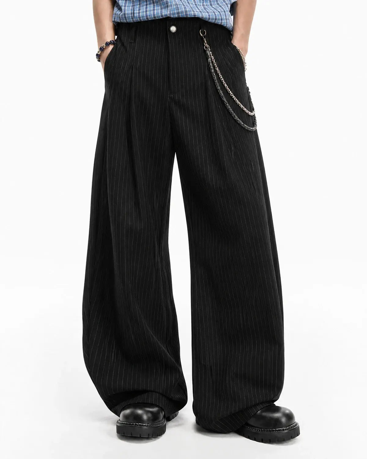 Flation pinstripe pleated barrel tailored pants showing high waist, pleats, and pinstripe fabric in a streetwear style.