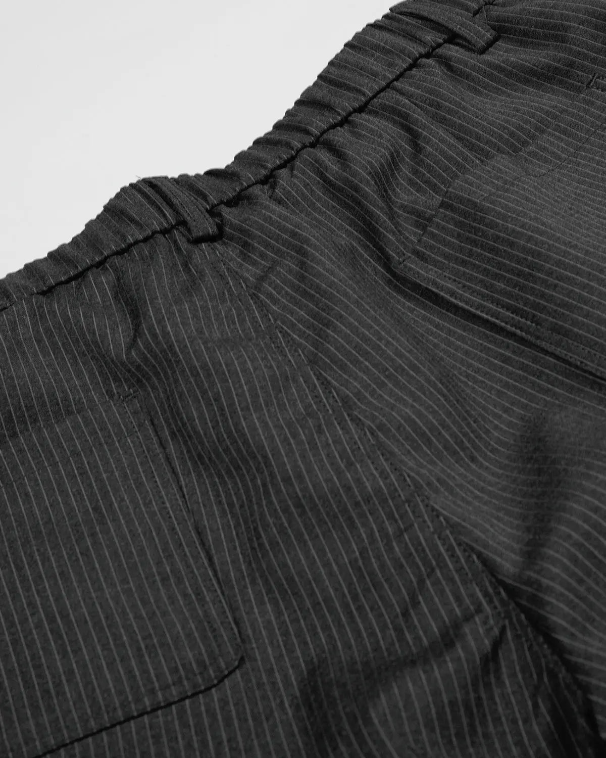 Flation pinstripe tailored shorts with stud details, featuring a slim fit design and classic waistband, perfect for streetwear style.