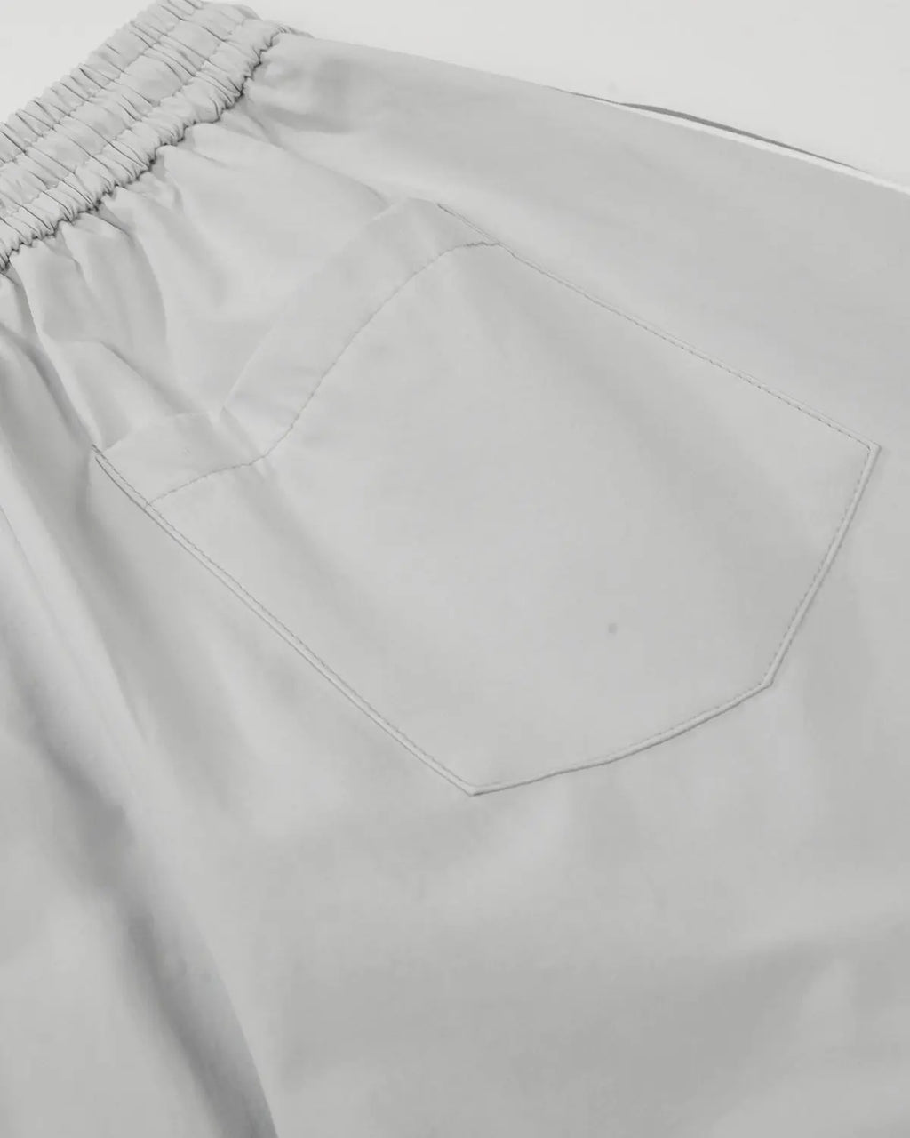 Grey Flation streetwear baggy track pants with contrast panel design, featuring a relaxed fit and casual style.