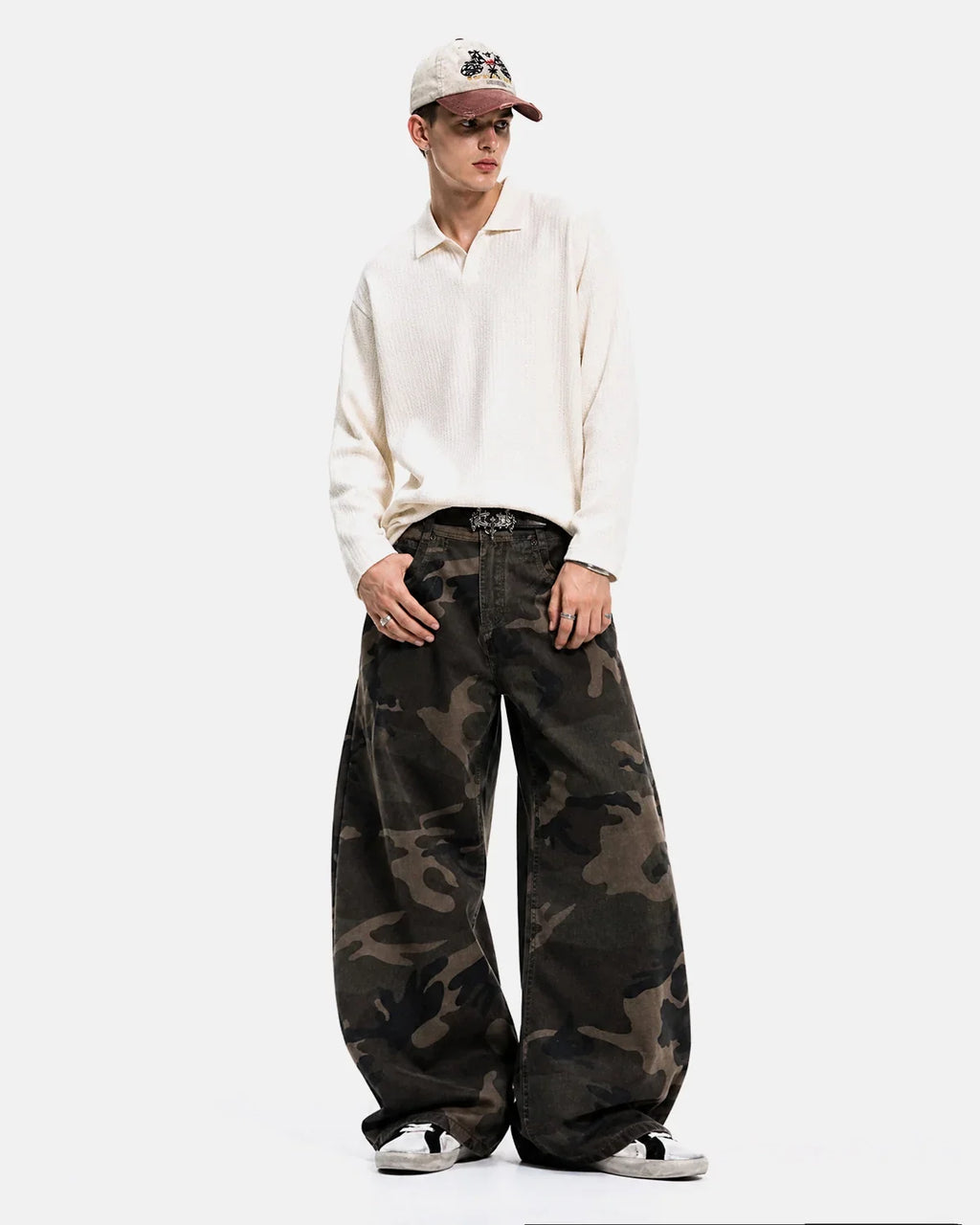 Flation studded camo barrel jeans with metal studs, featuring a tapered fit and streetwear style, shown on a model.
