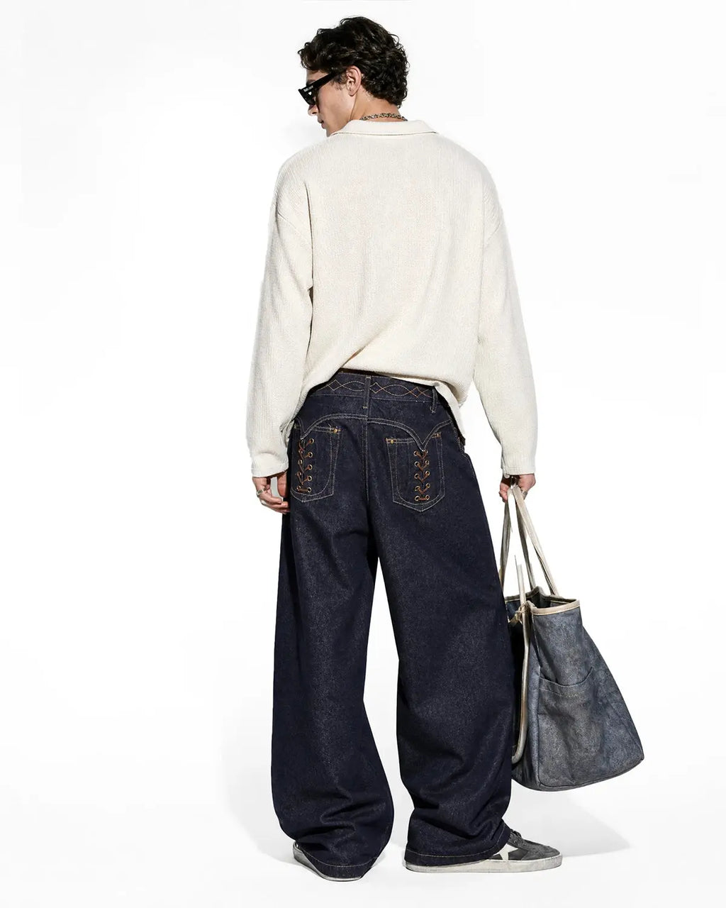 Black Flation streetwear raw baggy jeans with side lace-up design and relaxed fit, showcasing the denim's texture and style.
