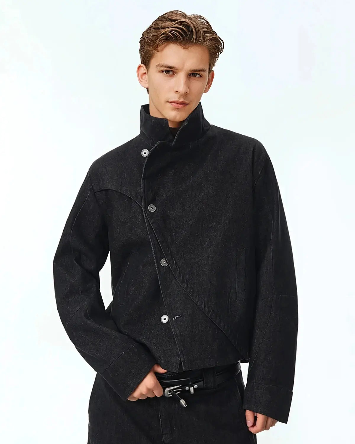 Cropped asymmetric denim jacket by Flation featuring button closure and streetwear style, shown on a model.