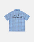 Plaid script embroidered short-sleeve shirt by Flation featuring a classic plaid pattern and embroidered lettering on the front.