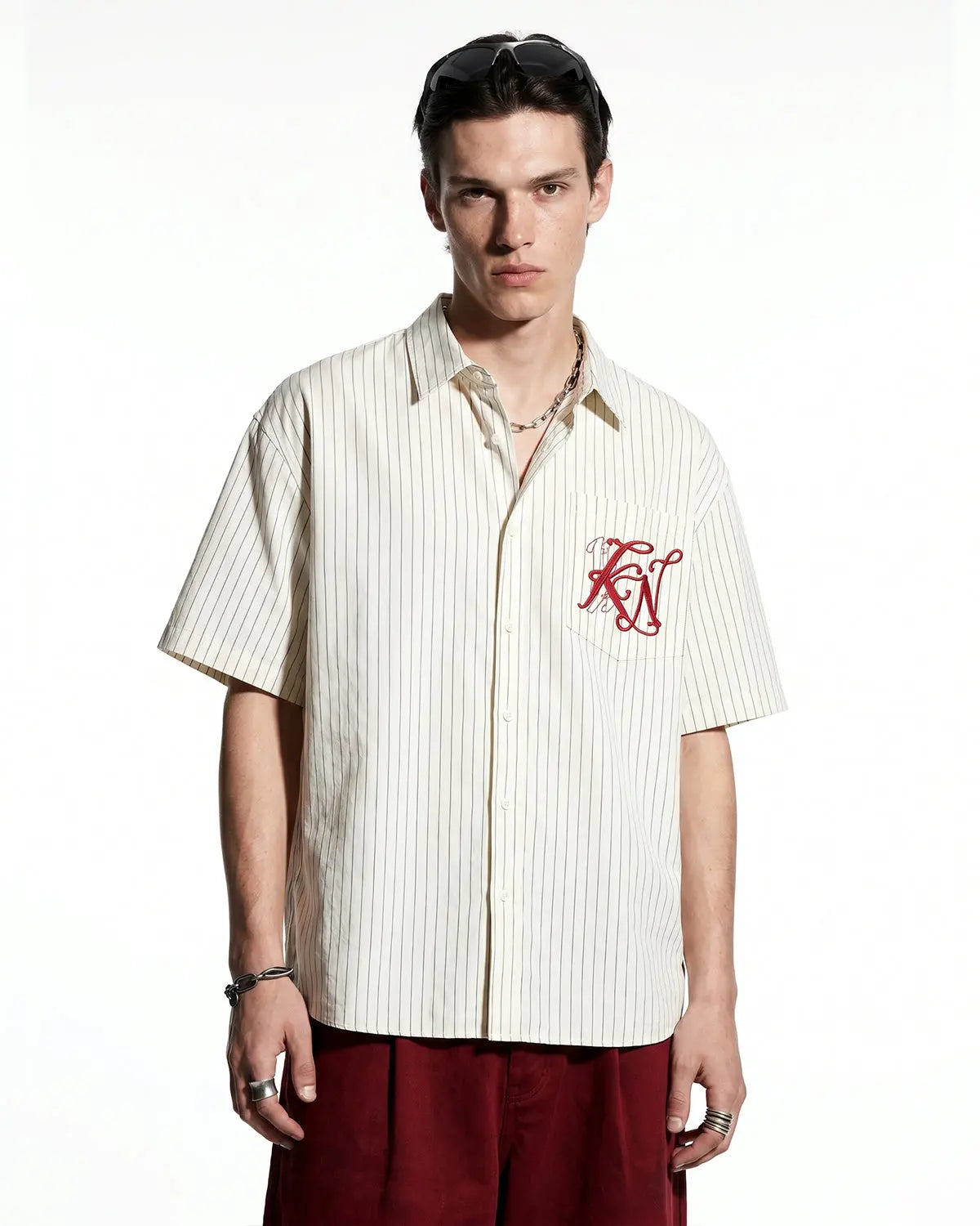 Striped embroidered short-sleeve shirt by Flation Streetwear, featuring colorful embroidery and casual fit, displayed on a hanger.