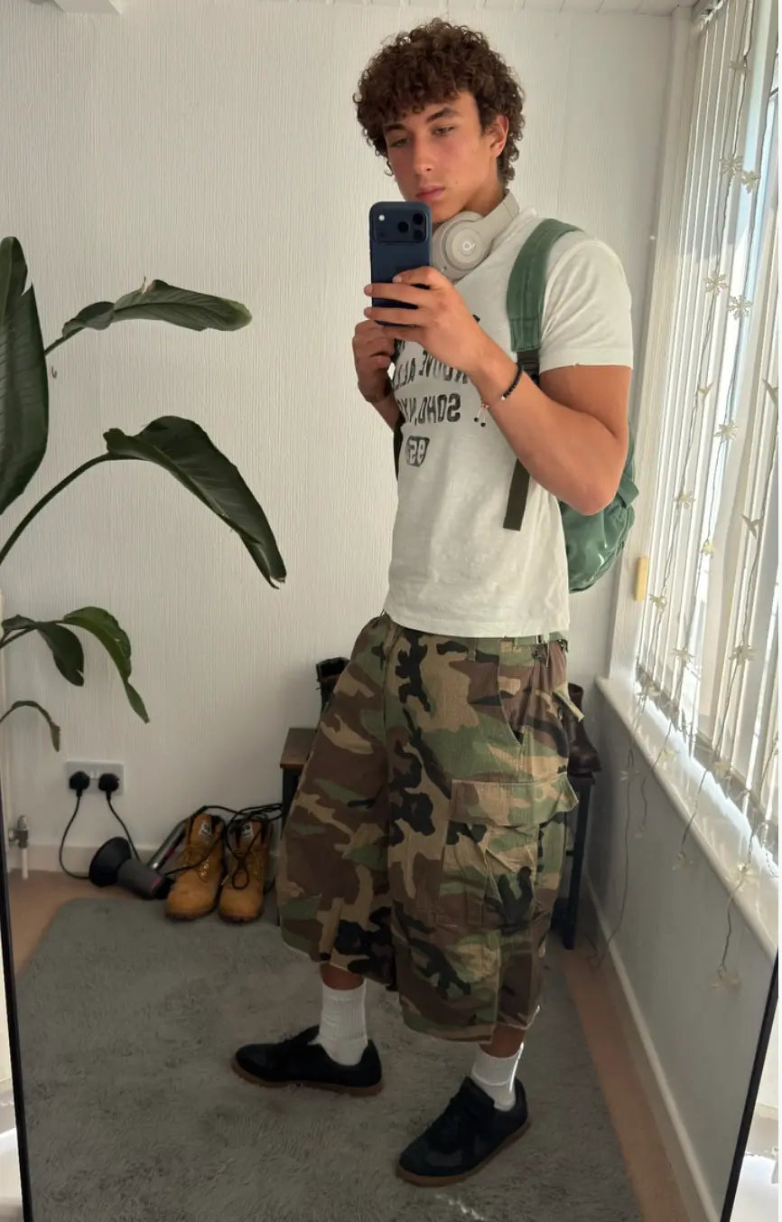Oversized camo cargo longline shorts by Flation featuring a loose fit, multiple pockets, and a modern streetwear style.