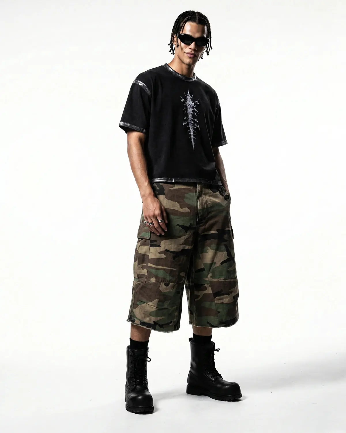 Flation oversized camo cargo longline shorts showing green and brown camouflage pattern with multiple pockets and relaxed fit.