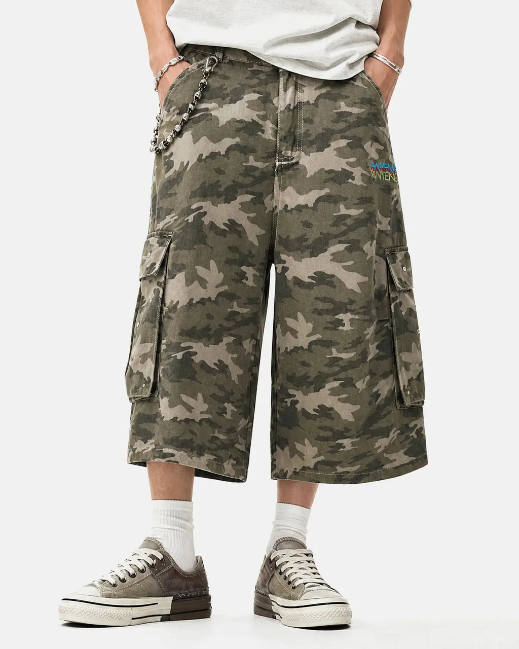 Embroidered camo cargo longline shorts by Flation Streetwear, featuring a relaxed fit and detailed embroidery on the fabric.